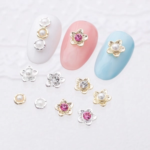 Floral nail art charms set with rhinestone petals and pearls on white background