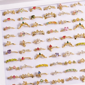 Detailed view of assorted gold rings with colorful gemstones and pearls in a display box