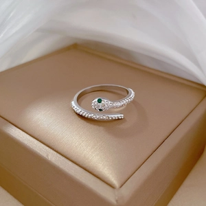 Macro shot of silver snake ring with pavé crystals and green emerald-style eyes