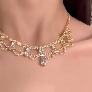 Detail of luxury teardrop necklace with lace design and crystals worn by a model