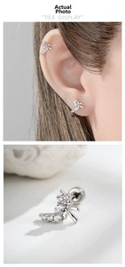 Macro detail of silver bow cartilage stud with zircon inlay and screw back closure