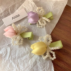 Detailed view of handmade tulip hair clips with silk fabric petals and white pearl beads