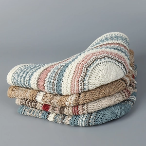 Close-up of stacked colorful striped crochet bucket hats showing rich knitted textures