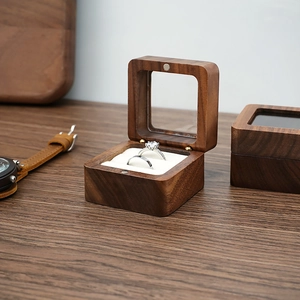 Detail of walnut wood ring box with double slots and soft white velvet lining interior