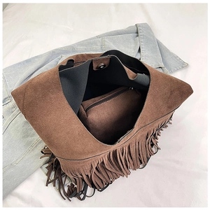 Detail of brown suede tote bag with fringe tassels and secure magnetic metal closure