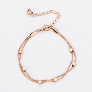 Detail of rose gold double-layered snake chain bracelet with square charms and clasp