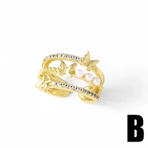 Golden butterfly cross ring with pearls and small diamonds on a clean white background