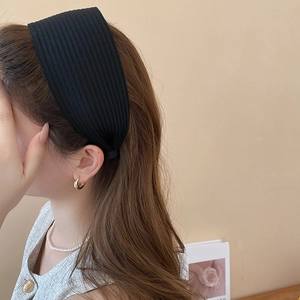 Detail eines breiten schwarzen Rippstrick-Stirnbands mit weicher Textur und elastischem Stoff