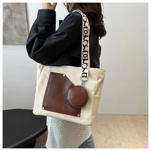 Large colorblock canvas tote bag with brown leather trim and wide patterned shoulder strap