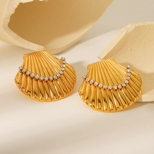 Macro detail of gold-plated stainless steel shell earrings with sparkling zircons