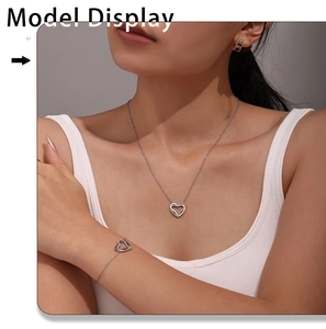 Modella indossa set con collana e bracciale a doppio cuore con zirconi incastonati