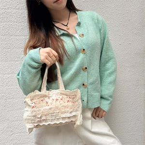 Vue détaillée d'un sac cabas floral en toile avec bordure en dentelle blanche et logo