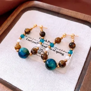 Créoles vintage avec perles et billes marbrées sur un présentoir élégant et chic