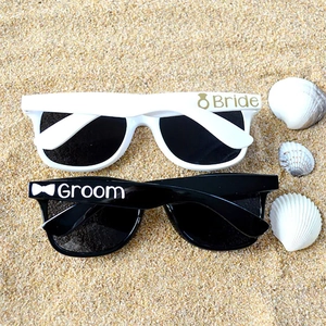 Bride and Groom wedding sunglasses set in black and white on a beach with shells