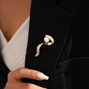 Elegant 14k gold plated twisted brooch with sparkling crystals and pearl on black blazer