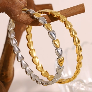 Minimalist 18K gold-plated stainless steel heart link bracelets on a wooden display stand