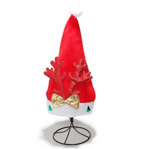 Detail of red plush Santa hat featuring sequined reindeer antlers and golden bow