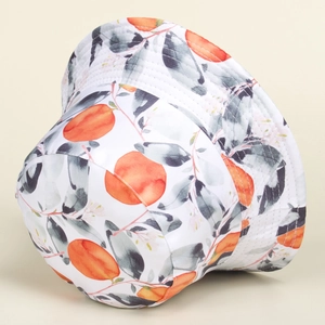 Close-up of white sun hat with orange fruit prints and textured cotton fabric detail