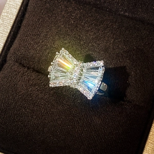 Close-up of a sparkling bow-shaped silver ring with clear zircons in a premium jewelry box