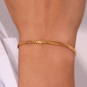 Macro shot of 18K gold plated stainless steel curb chain bracelet worn on a wrist