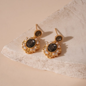 Vintage gold-plated earrings with grey oval stone and pearls on white stone base