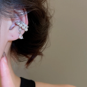 Detail of zircon and pearl ear cuff on ear with dangling water drop crystal
