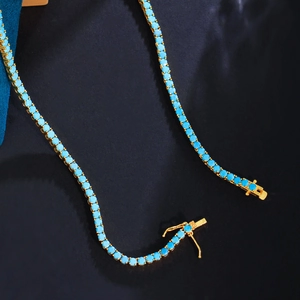 Detailed macro view of gold plated brass tennis chain with vibrant blue turquoise stones