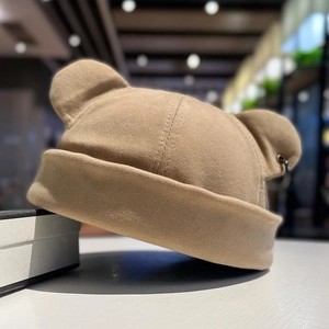 Detail of khaki knit docker hat featuring cute bear ears and a metal ring buckle accent