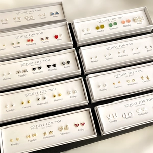 Detailed set of five pairs of minimalist stud earrings in a Monday to Friday gift box