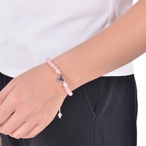 Close-up of pink zebra stone beaded bracelet with silver heart projection pendant on wrist