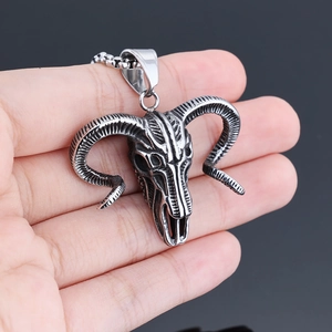 Detailed close-up of a vintage silver ram skull pendant with intricate curved horns