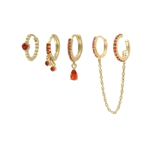Detailed macro view of 5-piece gold earring set with red zircon and chain fringe