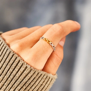 Detail of S925 silver infinity ring in two-tone gold and silver on model finger