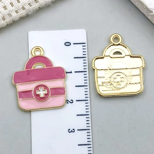 Pink enamel medical first aid kit charms in gold finish with size measurement