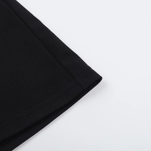 Vue détaillée de la double couture précise et de l'ourlet sur le tissu noir de la robe