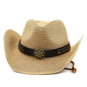 Dettaglio del cappello da cowboy in paglia con borchie e fibbia a girasole su pelle