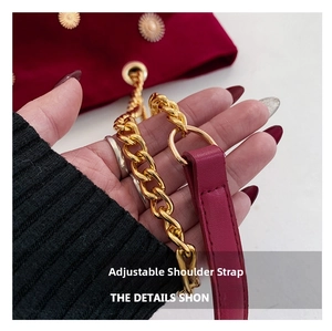 Detail of red velvet tote bag featuring golden sunflower charms and thick chain strap