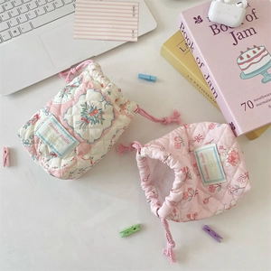 Quilted camera storage pouch with floral patterns and pink drawstring closure detail