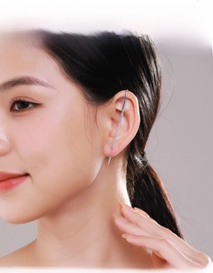 Dettaglio dell'orecchino ear cuff in argento S925 con cristalli blu sull'orecchio