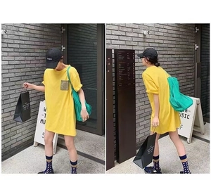 Detail view of bright yellow oversized t-shirt with chest pocket and green mesh tote bag