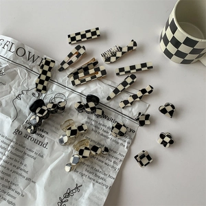 Checkerboard hair clip set featuring various geometric shapes on a white tabletop