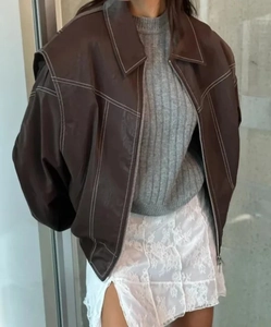 Dettaglio della giacca in pelle marrone vintage oversize con trama premium e stile street