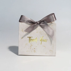 Detail of marble pattern gift box with gray satin bow and gold foil Thank You text