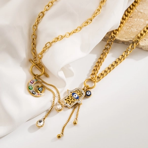 Détail des charms Main de Fatma et Œil de Protection sur un collier bohème lune dorée
