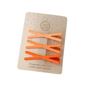Set of three matte gradient orange hair clips for girls on a beige handmade card display