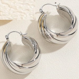 Macro shot of silver S925 hallmark on a multilayer twisted silver hoop earring
