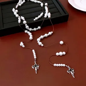 Gothic style glass pearl necklace with double cross pendants on leather background