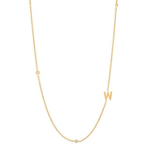 Detail of 18K gold plated necklace featuring a W letter pendant and bezel-set crystals