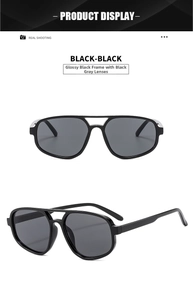 Close-up of glossy black double-bridge pilot sunglasses with dark grey lenses