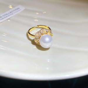 Macro detail of a gold flower ring featuring a large pearl surrounded by zircons